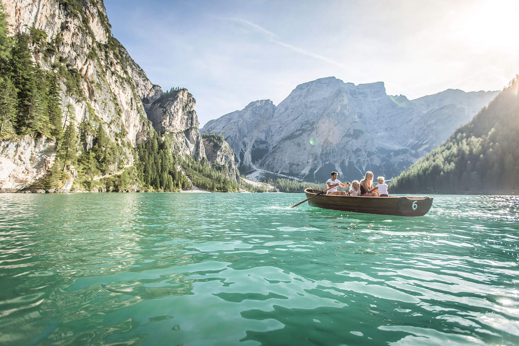 Eine Familie fährt mit einem Boot über den Pragser Wildsee - Kuenzerhof