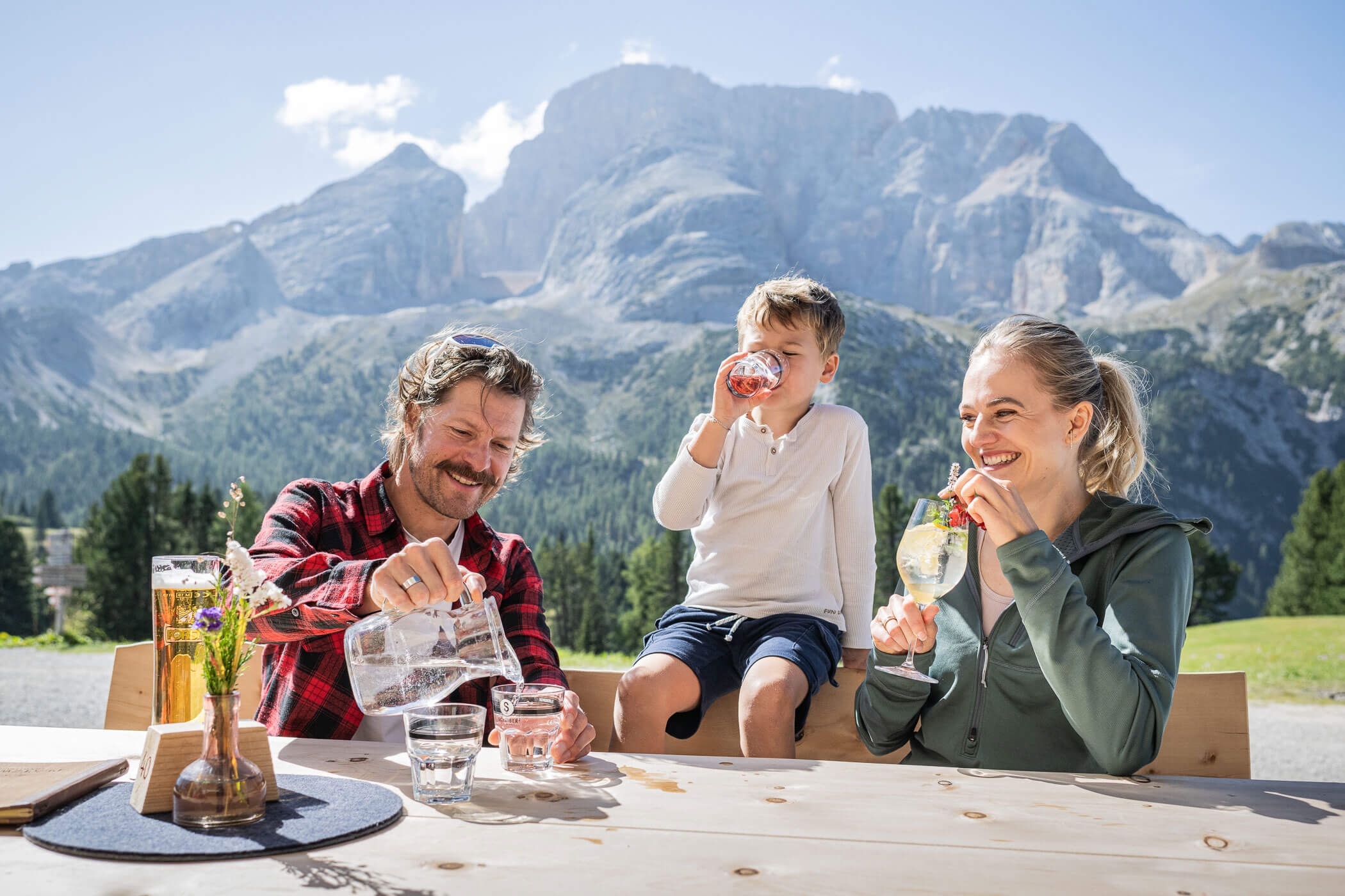 Eine Familie trinkt auf einer Almhütte etwas - Kuenzerhof